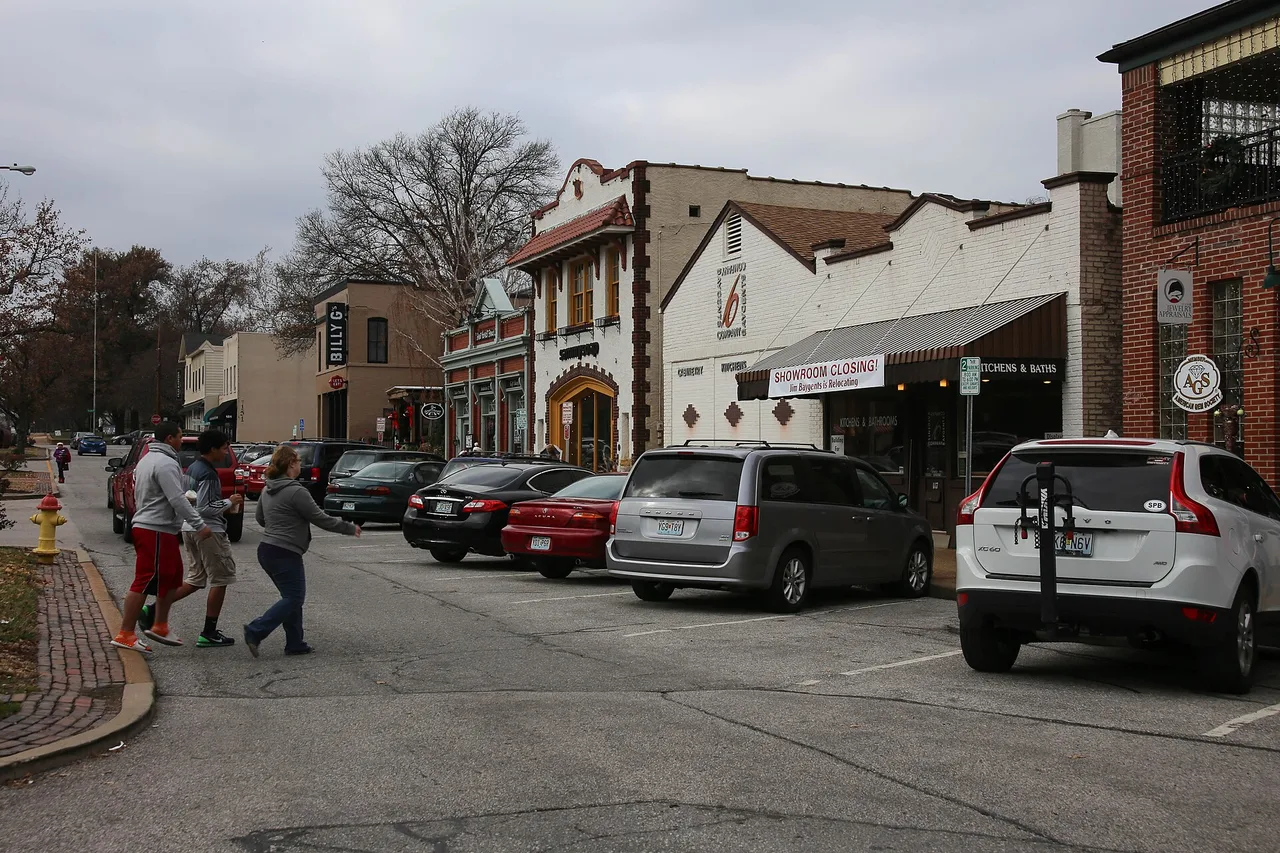 Downtown Kirkwood street with shops and pedestrians, including Billy G’s